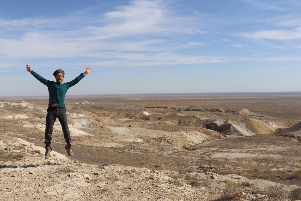 ein Sprung über dem Aral Canyon Viewpoint mit blick auf den trockenen Aralsee